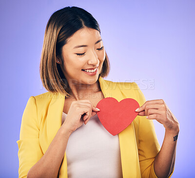 Buy stock photo Asian girl, support and paper heart for care with smile in studio with purple background with asian. Peace, wellness and woman with love sign for kindness or hope with happiness and romance emoji.