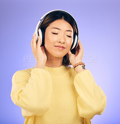 Buy stock photo Headphones, music and happy Asian woman relax in studio for streaming app, subscription and radio. Calm, podcast and isolated female person listening to audio, song and track on purple background