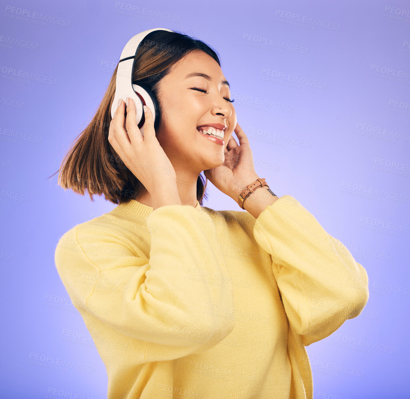 Buy stock photo Headphones, dance and happy Asian woman with music in studio for streaming app, subscription and radio. Excited, podcast and female person listening to audio, song and track on purple background