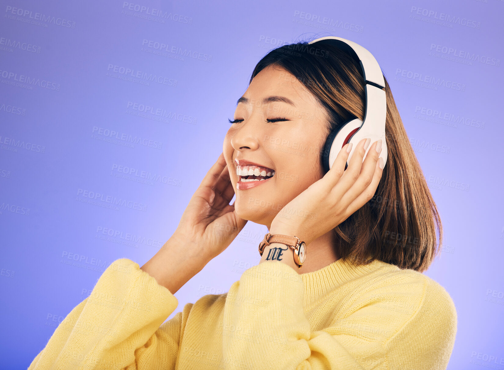 Buy stock photo Happy asian woman, headphones and listening to music for online streaming against a purple studio background. Female person or model smile enjoying audio track, sound or songs on headset on mockup