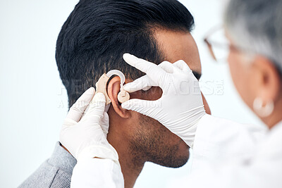 Buy stock photo Hearing aid, deaf man and doctor hands with patient consultation for ear and ENT check at hospital. Help, employee and medical test of physician with health insurance and consulting exam with expert