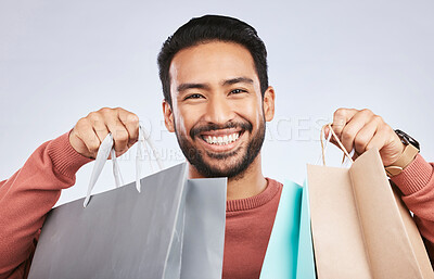 Shopping bag, studio portrait and man with happiness, retail product and smile for fashion spree, sales or Black Friday choice. Face, gift present and happy male customer excited on white background