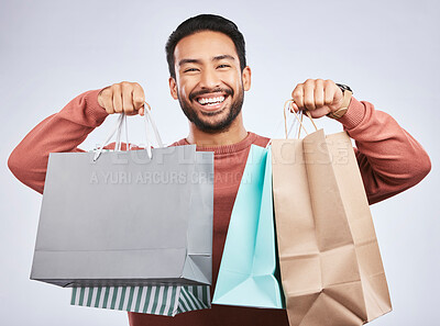 Buy stock photo Shopping bag, studio portrait and happy man customer or client with retail product, gift or fashion spree choice. Boutique discount deal, market present and excited person smile on white background