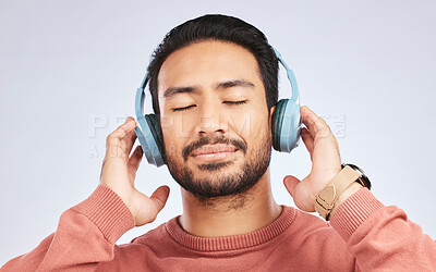 Buy stock photo Man, headphones and calm music in studio, white background and podcast for peace. Face of happy young asian male model listening to audio, streaming sound and hearing radio to relax with song in mind