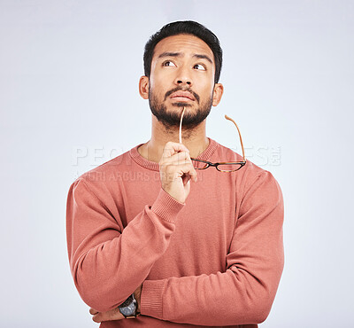 Buy stock photo Decision, thinking and asian man in studio with glasses, questions and brainstorming on grey background. Why, idea and male person with emoji, body language or choice gesture, puzzled or solution