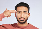Depression, portrait and sad asian man with hand gun in studio for suicide, trauma or ptsd fail on grey background. Stress, face and guy with weapon emoji for death, anxiety or mental health crisis