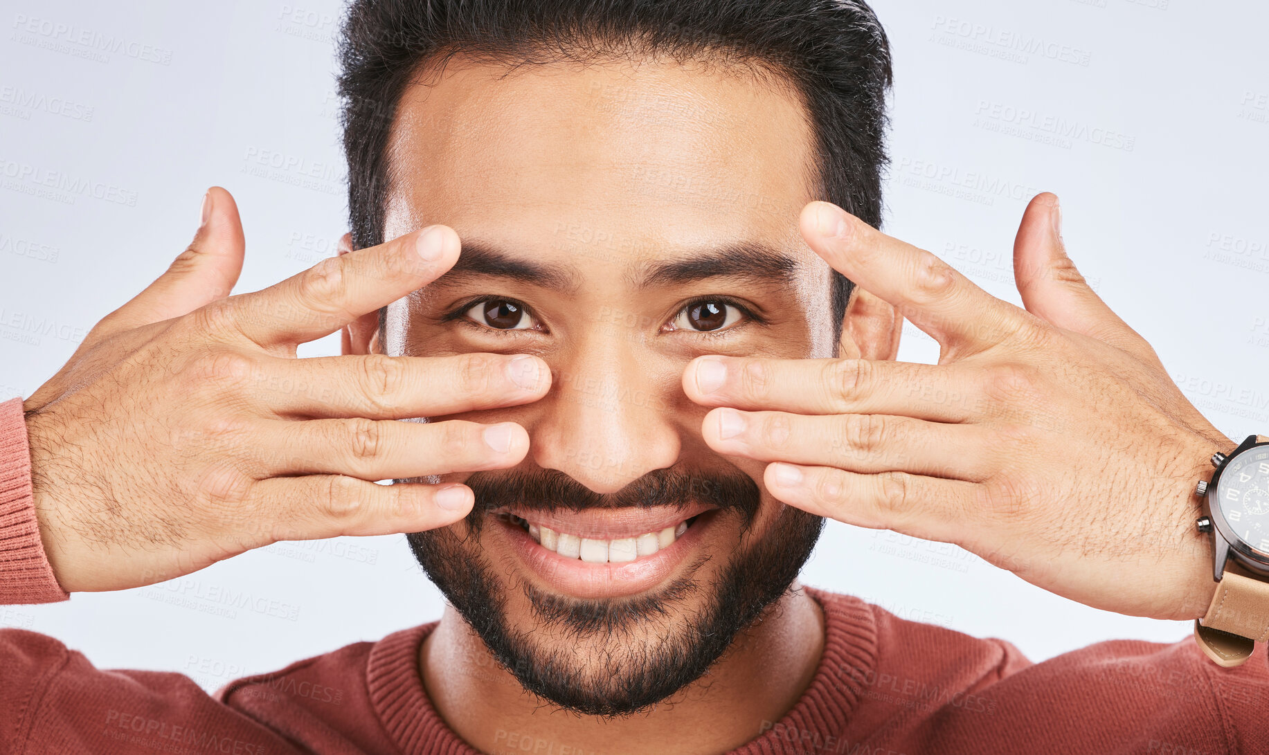 Buy stock photo Portrait, smile and asian man with fingers on eyes in studio with confidence, personality and persona on grey background. Hands, happy and male person with hand gesture for mask, masquerade or silly