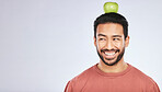 Head balance, thinking or happy man with apple decision for weight loss diet, healthy lifestyle change or nutrition choice. Studio food, fruit mockup space or hungry person ideas on white background
