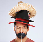 Photo booth, hat and portrait of man with mustache for comic, humor and funny joke in studio. Happy, Mexican party accessory and silly face of male person on gray background with sombrero for comedy