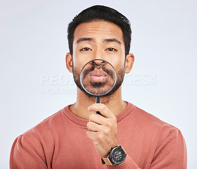 Buy stock photo Mouth, portrait of a man with a magnifying glass in hand on a white studio background for investigation. Face of Asian person or model with a magnifier to show lips or zoom for inspection or emoji