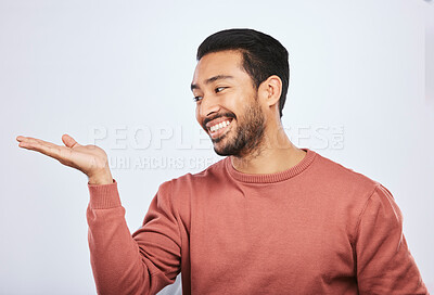 Buy stock photo Hand holding, space and happy asian man in studio with mockup, promotion or news on grey background. Smile, face and male person with platform for menu, product placement or sale announcement 