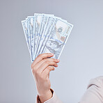 Money, hand and woman in studio with savings, success or cashback, reward and bonus on grey background. Cash, investment and female winner show casino, poker or gambling award with financial freedom