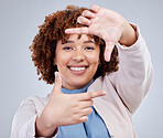 Hand, frame and happy woman portrait in studio with sign for photo, photography or fun picture on grey background. Face, lady and beauty influencer with emoji finger for social media or selfie smile