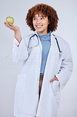 Buy stock photo Doctor, woman and smile with apple in studio, white background and wellness. Happy medical employee, female nutritionist and holding green fruits for vitamin c nutrition, healthy food and vegan diet