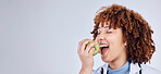 Doctor, woman and eating apple in studio, white background and mockup space. Face of medical employee, happy female nutritionist and bite fruits for vitamin c nutrition, healthy food and vegan diet