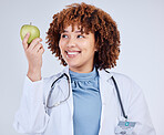 Doctor, happy woman and holding apple in white background, studio and vitamin c wellness. Medical employee, female nutritionist and smile with green fruits for nutrition, healthy food and vegan diet