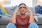Headache, stress and woman with depression from laundry in a living room, exhausted and unhappy in her home. Anxiety, migraine and female person overwhelmed with household, task or spring cleaning