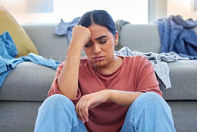 Buy stock photo Headache, depression and woman with stress from laundry in a living room, exhausted and unhappy in her home. Anxiety, migraine and female person overwhelmed with household, task or spring cleaning