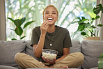 Woman is laughing, popcorn and watch a movie, comedy and entertainment, streaming service and relax at home. Female person, subscription and watching funny film or series with cinema snack on sofa