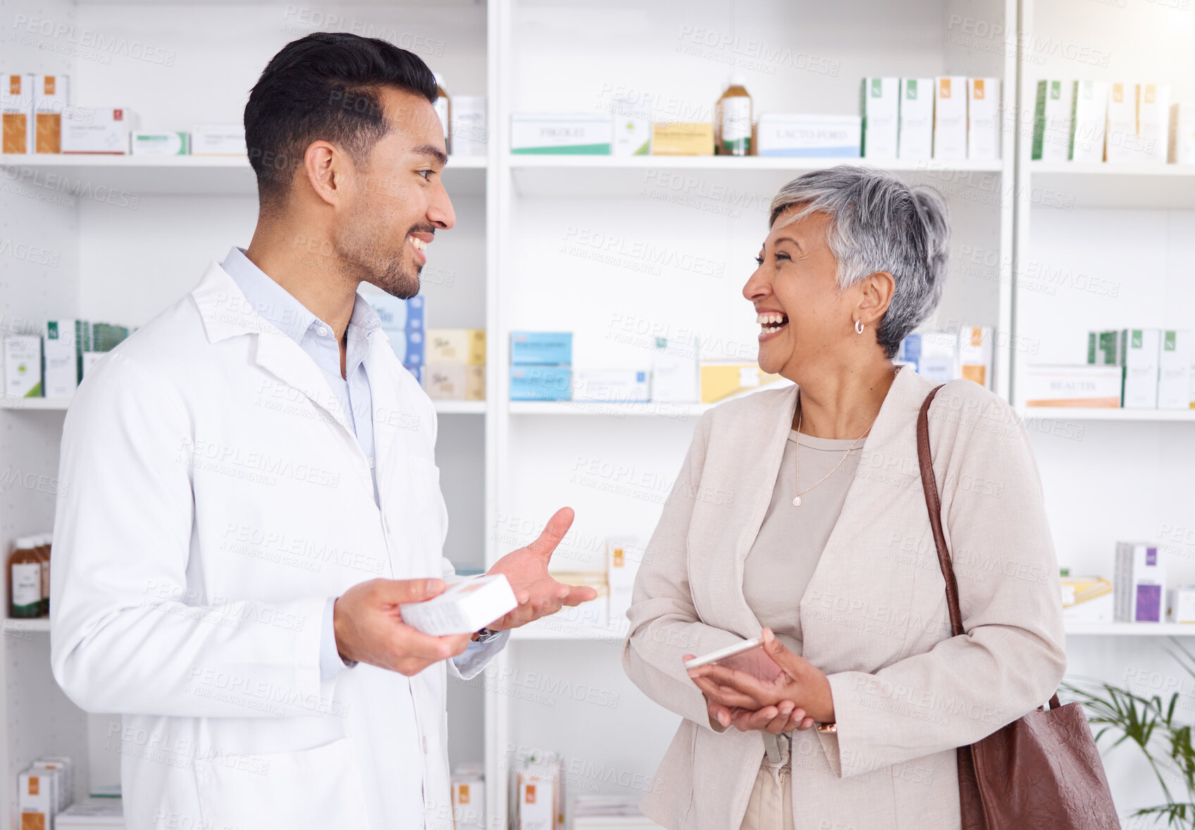 Buy stock photo Pharmacist man, senior woman and talking with box, phone or funny in store for prescription, health or help. Young pharmacy manager, elderly patient and comic chat for care with customer experience