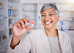 Pill, medicine and woman pharmacist happy for medical treatment in a pharmacy, dispensary or drugstore for health. Senior, healthcare and professional with a antibiotics drug for research in a clinic