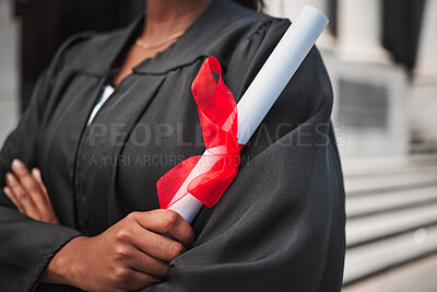 Buy stock photo University, graduation and certificate with a student arms crossed on campus, confident in her achievement. Diploma, education and college with an african graduate standing outdoor at a ceremony