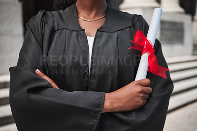 Buy stock photo Education, graduation and certificate with a student arms crossed on campus, confident in her achievement. Diploma, university or college with an african graduate standing outdoor at a ceremony