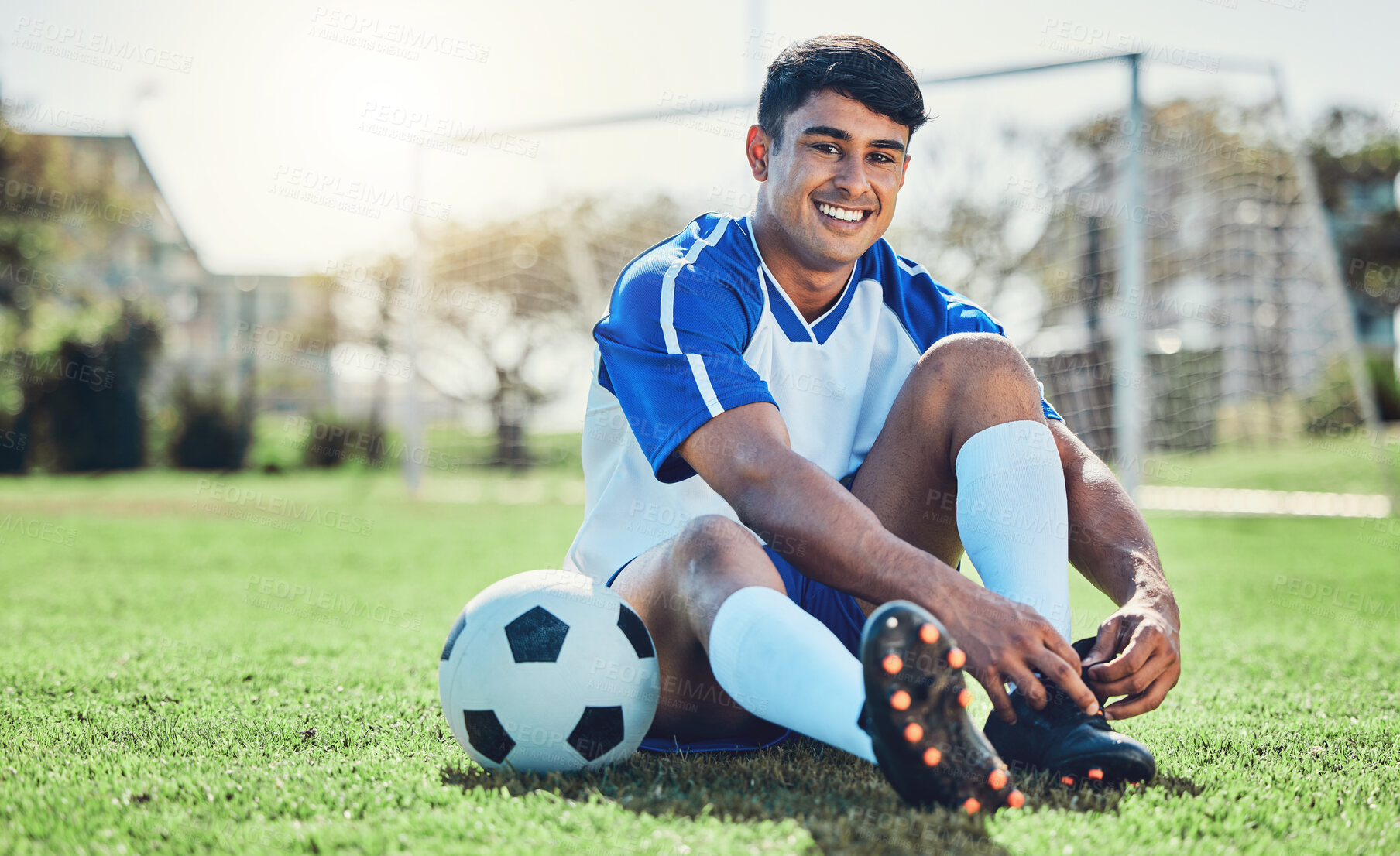 Buy stock photo Man, soccer field and tie shoes for sports training, fitness games and performance on stadium ground. Portrait, athlete and happy football player prepare lace sneakers on grass pitch for competition