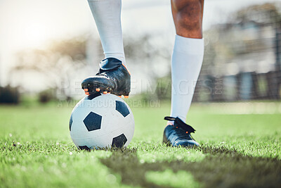 Legs, sports or man with a soccer ball on a field for exercise, fitness and training for a competition outdoors. Football club, ready or boots of player in a game event or match in stadium on grass