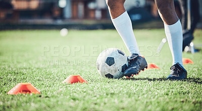 Soccer player, feet and ball with training cones on a field for sports game and fitness. Legs or shoes of male soccer or athlete person outdoor for agility, performance or training workout on a pitch