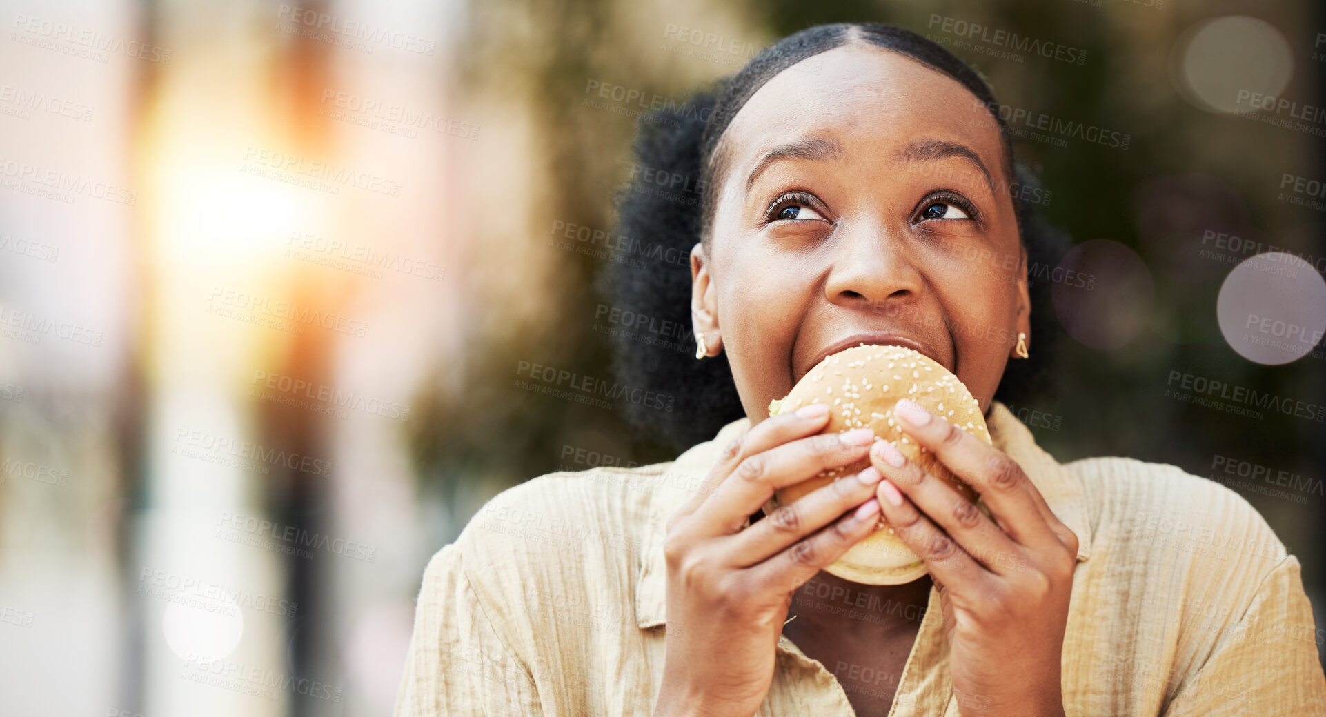 Buy stock photo Mockup, fast food and black woman eating a burger in an outdoor restaurant as a lunch meal craving deal. Breakfast, sandwich and young female person or customer enjoying a tasty unhealthy snack