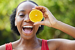 Happy black woman, face and orange for vitamin C, natural nutrition or citrus diet in nature outdoors. Portrait of African female person smile with organic fruit in healthy eating or wellness in park