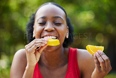 Buy stock photo Black woman, vitamin C and eating orange slice for natural nutrition or citrus diet in nature outdoors. Happy African female person enjoying bite of organic fruit for health and wellness in the park