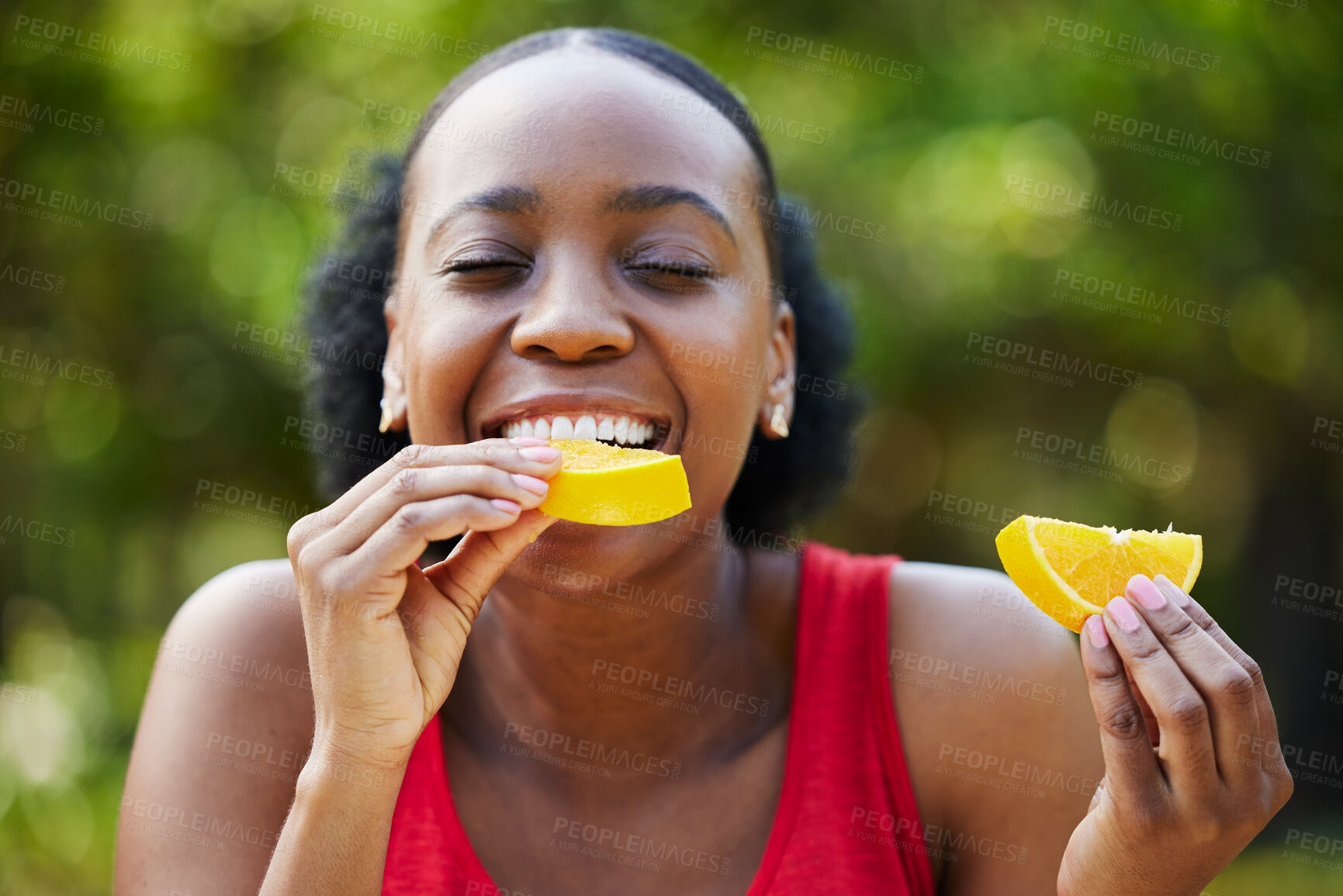 Buy stock photo Black woman, vitamin C and eating orange slice for natural nutrition or citrus diet in nature outdoors. Happy African female person enjoying bite of organic fruit for health and wellness in the park