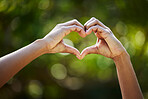 Hands, heart as a symbol or love or health with an african person outdoor in nature on a blurred background. Summer, romance or valentines day with an adult outside in a garden or yard during summer