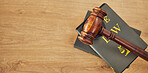 Gavel, law and books on wooden table, space or mockup for judge, justice or lawyer in courtroom. Background, hammer and research knowledge for legal study, constitution and truth, litigation or trial