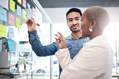 Buy stock photo Creative people, writing and meeting on glass board for schedule planning, strategy or brainstorming at office. Man and woman in teamwork for startup project plan, sticky note or tasks at workplace