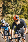 Men, mountain and cycling with fitness partnership, helmet and speed for training, exercise and health in summer. Young cyclist athlete, focus and vision for race, performance and workout in sunshine