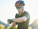 Watch, nature and cyclist checking his pulse while cycling for fitness or exercise on a mountain. Sports, bicycle and young male athlete with time for heart rate while training for a race or marathon