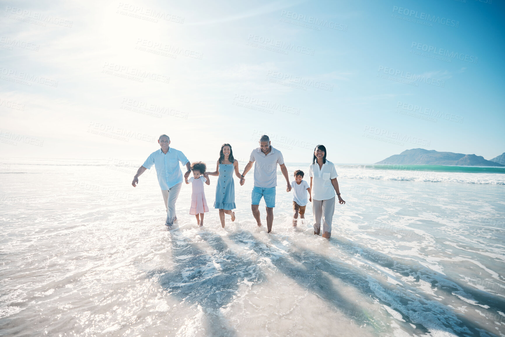 Buy stock photo Water, beach and happy family walking at the sea or ocean bonding for love, care and happiness together. Happy, sun and parents with children or kids and grandparents on a holiday for freedom