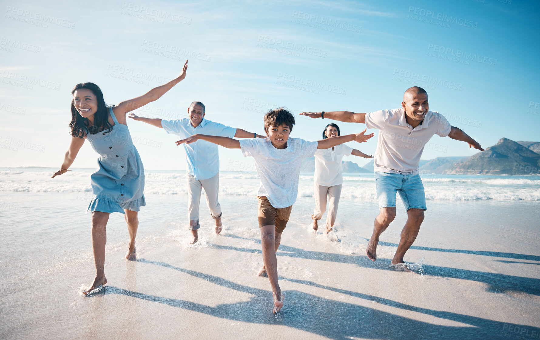 Buy stock photo Fly, beach and happy family running on vacation together at sea or ocean bonding for love, care and happiness. Summer, sun and parents with children or kids and grandparents on holiday for freedom