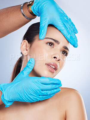 Woman, plastic surgery and hands on face in studio, check and cosmetics for beauty vision by background. Young girl, model and surgeon gloves with thinking, inspection and measurement for aesthetic