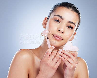 Buy stock photo Beauty, facial roller and skin portrait of a woman in studio with skincare tools for natural glow. Face of a female aesthetic model on a gradient background for shine, cosmetics and self care massage