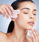 Gua sha, massage and asian woman with skincare tool in studio for anti aging, circulation or fine lines on grey background. Rose quartz, beauty and lady model with face crystal or lymphatic drainage 