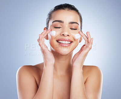 Buy stock photo Skincare, hand and happy woman with face cream in studio for anti aging, wellness or hydration on grey background. Facial, smile and latino model with sunscreen, lotion or beauty mask application