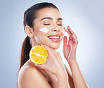 Lemon, skincare and asian woman with face cream in studio for wellness or cosmetic mask on grey background. Citrus, fruit and lady with facial for dark spots, melasma or acne prevention or sunscreen