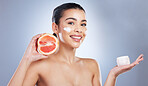 Skincare, face cream and woman with grapefruit in studio for a natural, organic or health facial routine. Beauty, self care and female model with citrus fruit and spf for treatment by gray background