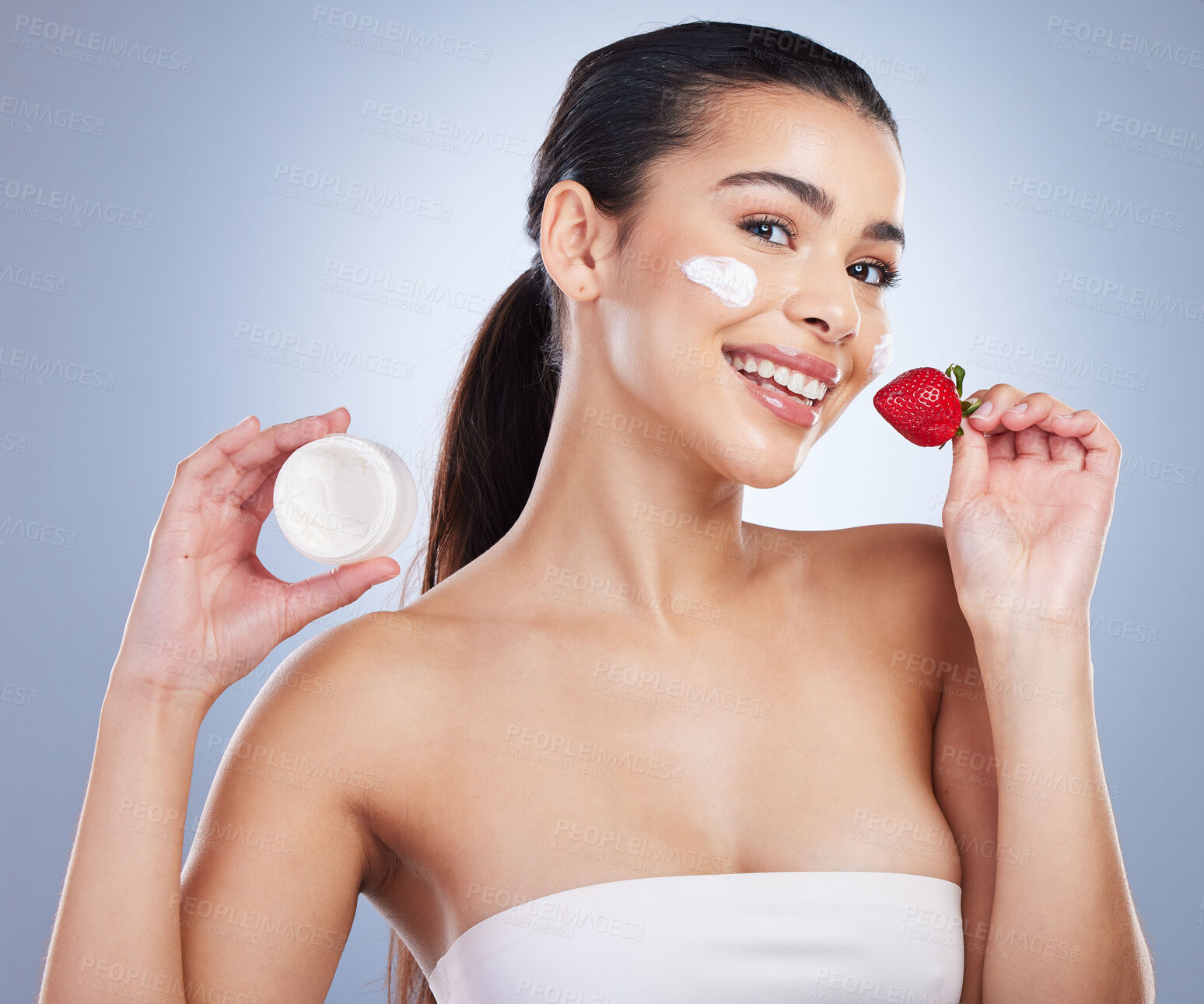 Buy stock photo Beauty, face cream and portrait of woman with strawberry in studio for natural, health or wellness routine. Skincare, self care and female model with fruit for facial treatment by a gray background.