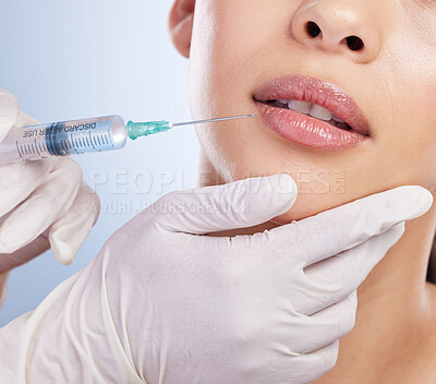 Lips, botox and plastic surgery with hands on the face of a woman for cosmetic surgery in studio on a blue background. Mouth, filler or beauty and a female patient with her doctor for an injection