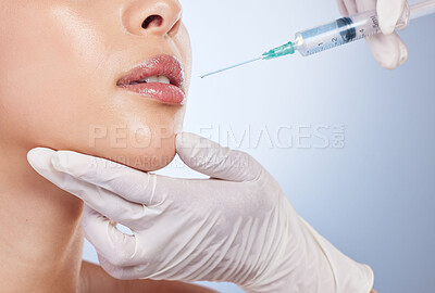 Mouth, botox and plastic surgery with hands on the face of a woman for cosmetic surgery in studio on a blue background. Lips, filler or beauty and a female patient with her doctor for an injection